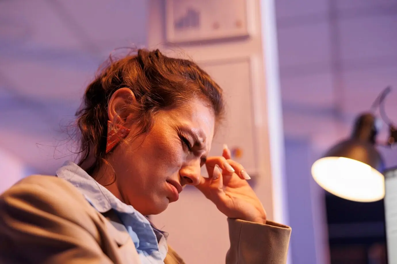 Erschöpfte Geschäftsfrau leistet Überstunden an einem Bericht über das finanzielle Wachstum.